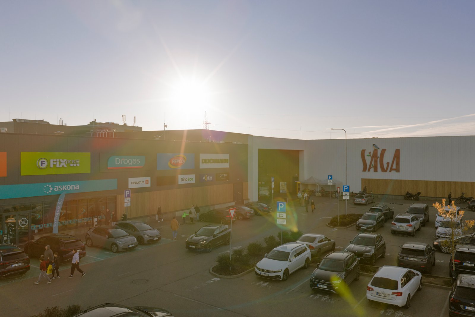 Tirdzniecības centra ieejas zona pretgaismā ar sauli kadrā